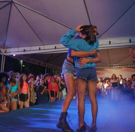 Oponentes de batalha de dança se abraçam no palco do Ball de Todas as Cores, segunda edição, no Beco da Codorna